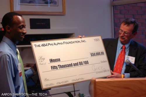 iHouse Treasurer Guy-Richard Kayombya ’08 (left) accepts a donation from Carl K. King ’65 (right) on behalf of the 484 Phi Alpha Foundation at the new undergraduate residence’s grand opening on Tuesday.