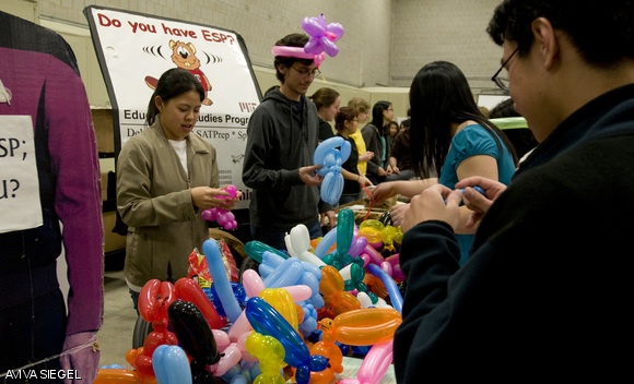 Members of ESP (Educational Studies Program) make balloon animals for prospective students at the CPW festival in the Johnson Ice Rink on Thursday night.