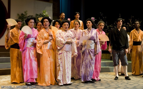 The gentlemen and schoolgirls of Titipu accompany Nanki-Poo (in black, right), a traveling minstrel, in song.