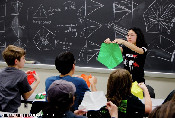 Michelle Fung ’13 shows students how to fold a pentagonal rose during OrigaMIT’s first origami conference on Saturday.