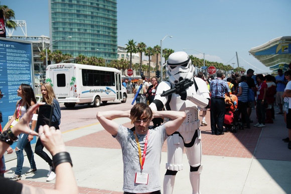 A stormtrooper holds a convention-goer hostage for the paparazzi.