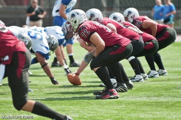 The offensive line prepares for the football to be snapped during the team’s season-opening game against Becker College. The team won 28-21.