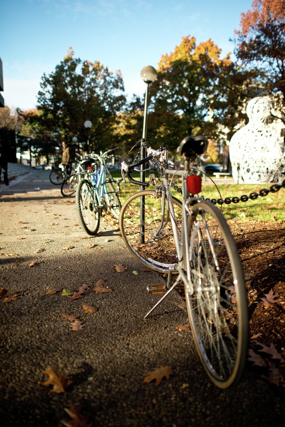 By Jessica L. Wass Photo Editor Bicycles chained up outside the student center combined with a shallow depth of field provided for an interesting sight last Sunday. The fall colors in the background lend a colorful atmosphere to the photo, much as the changing leaves have done to all of campus this fall. Aperture:
ƒ/1.4 Exposure Time:
1/5000 sec. Sensitivity:
ISO 400 Effective Focal Length:
24 mm