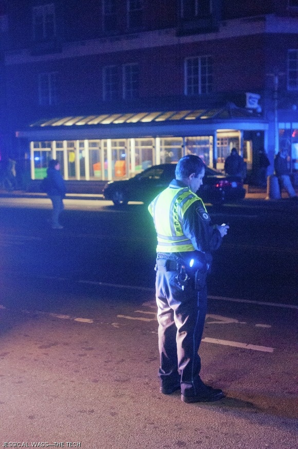 A police officer directs traffic on Mass. Ave in Central Square.
