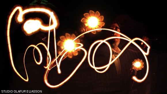 Eliasson creating light graphite with one of his inventions, “Little Sun,” a solar-powered lamp for developing countries.