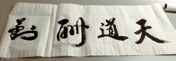 The Chinese characters for the phrase “Heaven Rewards the Diligent” written in calligraphy by a student lay on a table at the Ashdown Lunar New Year Event.