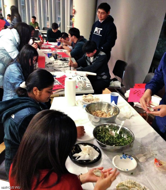 Students participate in different Lunar New Year traditions: making dumplings, writing calligraphy, and papercutting.