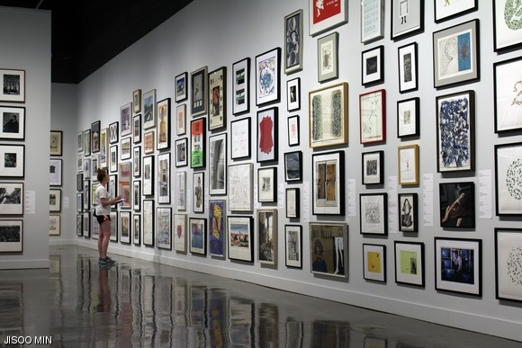 A student browses the selection of artwork available through the Student Loan Art Program at the List Visual Arts Center.