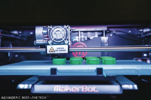 A MakerBot 3D printer prints plastic parts during the hackathon.