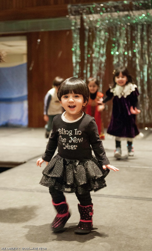 A young girl plays on the stage while dinner is served.