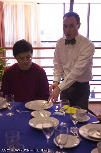 David N. Rogers, assistant dean and director of Fraternities, Sororities, and Independent Living Groups, shows Yuan K. Shen G the proper method of cutting meat at Charm School on Feb. 2.