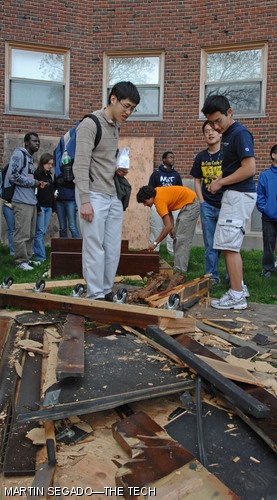 Students climb over the wreckage of the Baker House piano drop in search of salvageable parts.