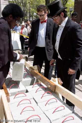 Teammates Sanusi A. Dantata '07, Aaron S. Sarfati '07, and Thomas A. Hopkin '07 load the final concrete block on the bridge that they, along with two other teammates, built as their final project for Senior Civil and Environmental Design (1.013). The bridges were required to have a span of ten feet, hold 2,000 pounds, and minimize deflection under a load.