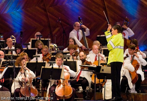 Boston Pops conductor Keith Lockhart, wearing a policeman's raincoat due to the inclement weather, directs the 1812 Overture during Boston's 2007 Independence Day celebrations at the Hatch Shell. See more photos on pages 6 and 7.