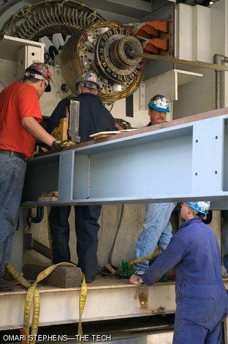 At the MIT Cogeneration Plant, Rich Hagar (bottom right) pumps a hydraulic jack piston as (top, left to right) Donny Warner, Denis Tebo, and Ricky Parker keep a close eye on the operation. The contractors inserted a 20-ton generator part this past Wednesday, Sept. 12 after it returned from repair.