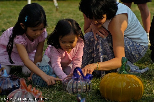 A family examines a blown glass pumpkin at the annual Great Glass Pumpkin Patch on Saturday, Oct. 6. Approximately 1,000 pumpkins were displayed for sale on Kresge Oval to benefit the MIT Glass Lab.