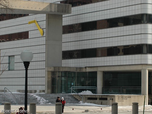 Hackers placed a large yellow crank on the side of the Media Lab on Sunday, in the style of the crank that powers the "One Laptop Per Child" laptops that were developed at the lab. Smaller cranks were "installed" on various objects across campus. According to the hackers, between ninety and one hundred of the smaller cranks were deployed.