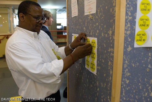 James L. Sherley tacks up sheets of stickers on the first floor of the Student Center proclaiming “Say No To June 30,” which refers to his last official date of employment at MIT after being denied tenure.