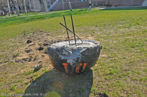 The bomb-shaped concrete block advertising DTYD, showing damage from an attempted detonation by the Cambridge Bomb Squad.