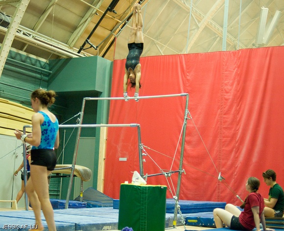 Zara K. Karuman ’13 performs a handstand on the uneven bars as her teammates look on during gymnastics practice on Thursday in DuPont. Due to budget cuts, the gymnastics team lost its varsity status at the end of last academic year and is now a club sport.