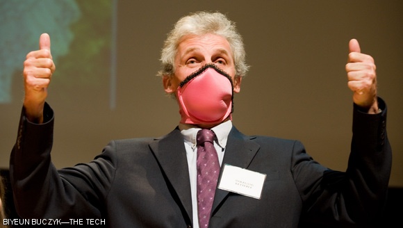 While wearing a brassiere over his mouth, Professor of Physics Wolfgang Ketterle, recipient of the Nobel Prize in Physics in 2001, gives two thumbs up to the winner of this year’s Ig Nobel Public Health Prize. The winner, Dr. Elena N. Bodnar, created a bra that can be taken off and used as a “gas mask” in the event of an emergency.