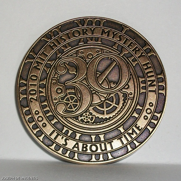 The 2010 Mystery Hunt coin was designed to look like a pocket watch, recalling the time travel theme of the Hunt. The obverse of the coin bears the inscriptions “2010 MIT History Mystery Hunt” and “It’s About Time.” The back includes all of the years used for additional rounds in the Hunt.