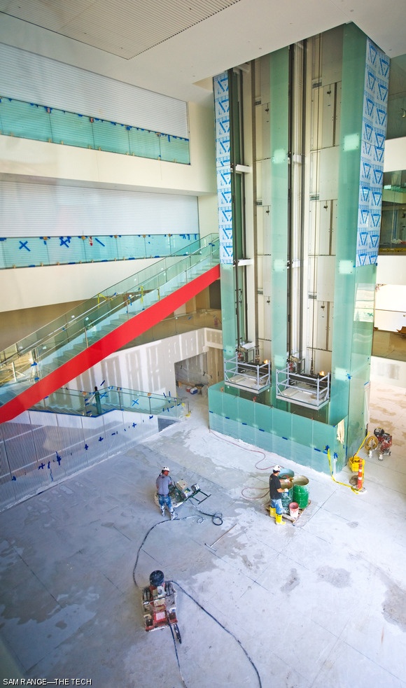 Workers began grinding the marble chunk-infused floor of the Media Lab extension’s central atrium on Nov. 2, which is now polished to a glossy finish. The expanse of interconnected airspaces surrounding the atrium necessitated smoke curtains (left) for emergency air evacuation, shown here closed for testing. The Media Lab extension opened in early December.