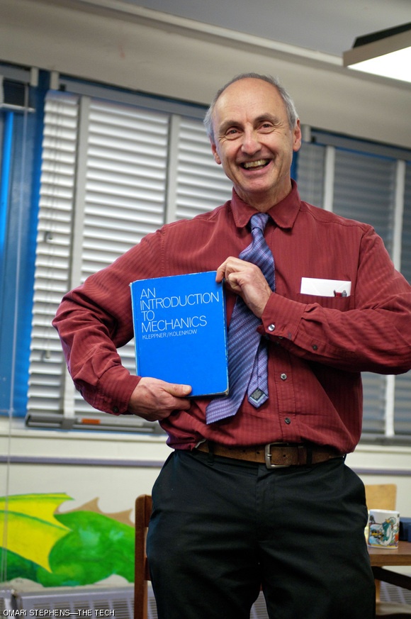 Peter Dourmashkin, outgoing lecturer and an associate director of the Experimental Study Group, poses with the textbook he used while teaching 8.012 at ESG. After a 28-year tenure with ESG, Dourmashkin, who was also one of the principal investigators of the TEAL program, will continue to work in Physics Department. The ESG community held an appreciation party for Dourmashkin on Tuesday, Jan. 11.