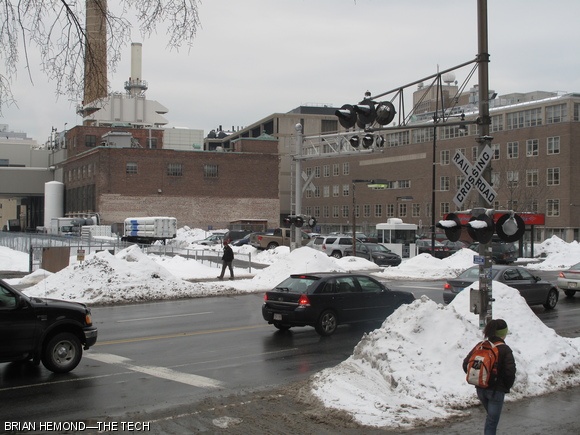 Rush hour traffic and pedestrians cross the railroad tracks that border MIT’s campus where they intersect Massachusetts Avenue. The Massachusetts Bay Transit Authority is considering upgrading these rails for commuter rail use, which would lead to increased train traffic at busy intersections like this one.