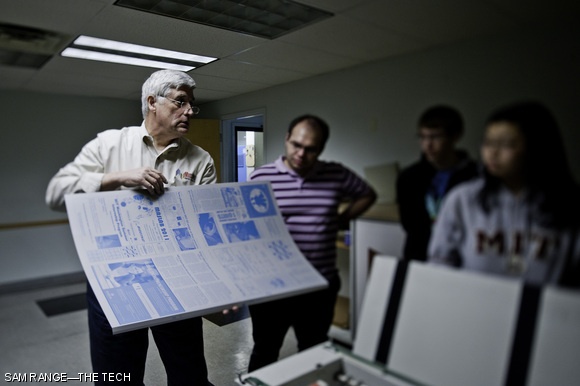 Robert D. Allen, Sales Manager at Mass Web Printing Co., displays a freshly-printed and folded black ink plate. Each plate contains the pattern for one color of ink for four pages of The Tech.