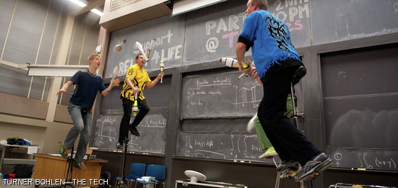 MIT freshman Stephen A. McCrory (front left) passes clubs with professional jugglers Peter Panic, Dan Foley, and Joel Harris while all four balance atop 5–7 foot tall unicycles. This performance rounded out a night of juggling last Friday evening at Juggle Mania in 54-100.