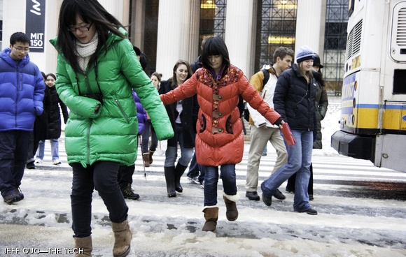 Students circumvent puddles as they cross Mass. Ave. It has already snowed 10.4 inches this month.