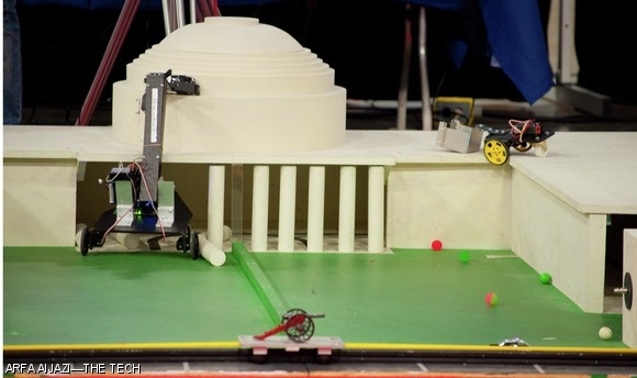 The theme of this year’s 2.007 (Design and Manufacturing I) competition was “MIT’s Greatest Hacks” in honor of the Institute’s 150th anniversary. The four tasks that the teams’ robots had to complete were placing a police car on the dome, pulling the Caltech cannon, dropping five bouncing balls, and inflating a weather balloon on the Harvard football field.