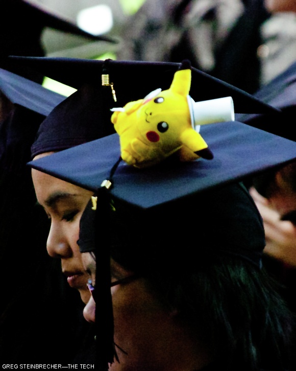 A stuffed Pikachu is visible on one graduate’s mortarboard. Other creative designs included a graduated cylinder and flags of different nations.