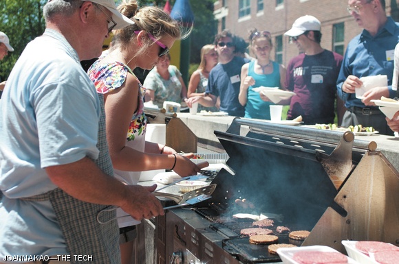 MIT alumni and current students line up on Sunday at the MIT Club of Boston (MIT COB) barbecue to grab food off the grill prepared by MIT COB volunteers. Over 300 people attended, and nearly 70 people volunteered for the annual event held in the courtyard of the Sidney-Pacific Graduate Residence.