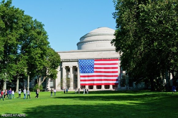 Members of the MIT community pause to take pictures of the flag hung underneath the dome after the Sept. 11 reflection ceremony Sunday.