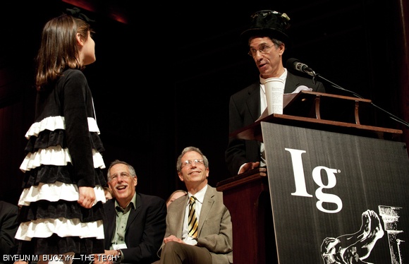 Marc Abrahams, the director and producer of the Ig Nobels, introduces Miss Sweetie Poo Liraz Brand. Miss Sweetie Poo is responsible for keeping the ceremonies running on time. If a guest’s speech goes over time, she walks to the podium and repeats, “Please stop, I’m bored,” until the guest stops talking.