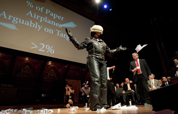 A human target stands on stage as people throw paper airplanes across Sanders Theatre, a long time tradition of the Ig Nobels.