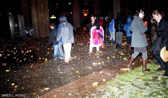Spectators and participants at Pumpkin Drop walk through the remnants of the dropped pumpkins in front of the Green Building on Saturday evening.