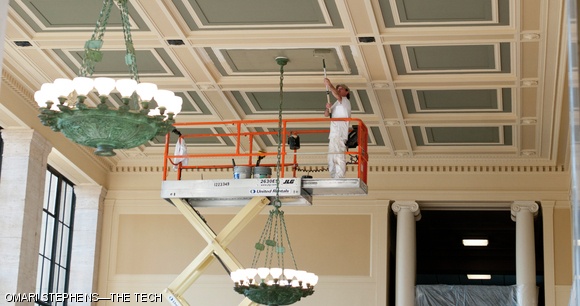 Ray Gelinas of Canning Studios uses a roller to paint the ceiling of Lobby 10 during a restoration project planned to be completed before February. Canning Studios founder John Canning explained that the group took a sample of the ceiling, analyzed it, and used the analysis to determine the original colors of the ceiling to the best of their ability. Canning emphasized that the green color of the ceiling provides a natural complement to the color of the bronze chandeliers.
