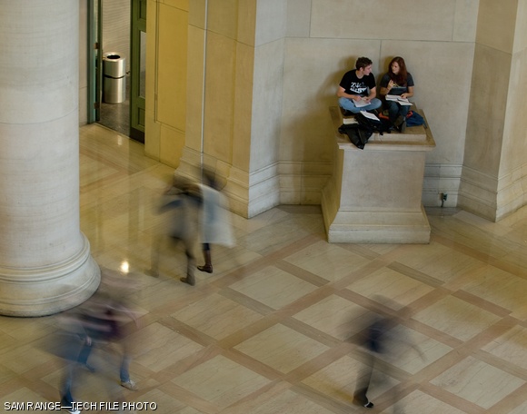 Students sit atop a plinth in the corner of Lobby 7 as pedestrians walk past on Nov. 5, 2009. The Class of 1954 is sponsoring a student contest for designs to sit atop the pedestals, which were left unfinished after Lobby 7 was designed in 1939.
