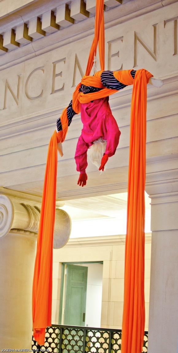 One fake acrobat hangs from an aerial silk.