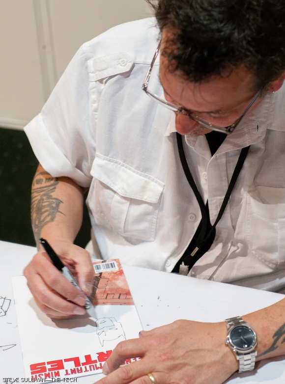 Teenage Mutant Ninja Turtles co-creator Kevin Eastman inks a sketch for a fan at his booth in the main hallway.