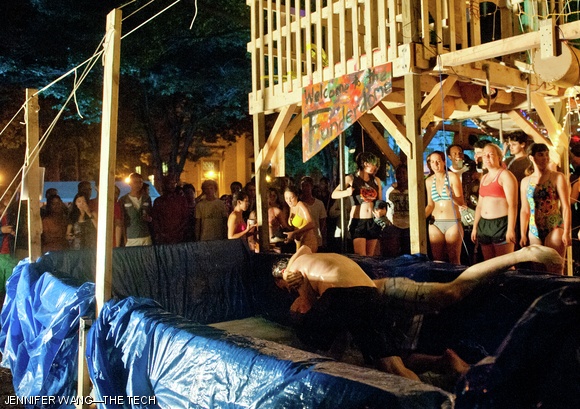 A crowd of party-goers cheers on two students wrestling in a tub of soap, water, and glitter during the East Side party on Monday, August 27.