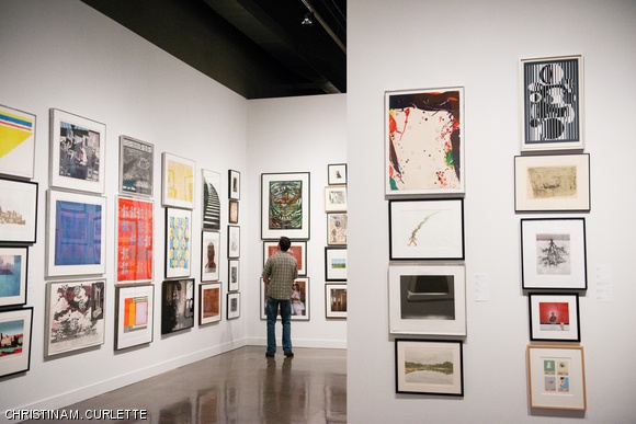 An MIT graduate student peruses an art piece in the Wiesner Building Wednesday evening during a special reception held in conjunction with the annual Student Loan Art Program Exhibition. The program allows students to borrow framed artwork from a collection of about 500 pieces.
