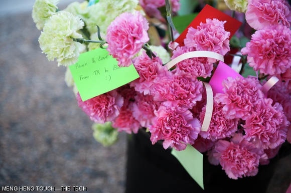 Students tied well-wished messages to flowers set up by the organizers of the commemoration event held on Kresge lawn Wednesday afternoon.
