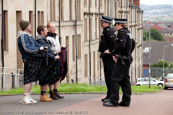 (Left to right) Albert (Gary Maitland), Robbie (Paul Brannigan), and Rhino (William Ruane) with policemen.