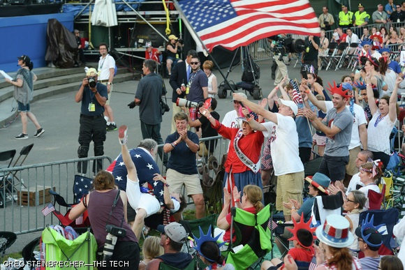 MIT Police Sergeant Cheryl Vossmer cheers as a couple swing dances during the Boston Pops concert. Several other onlookers, including the flag-waver, sport “Collier Strong” shirts.
