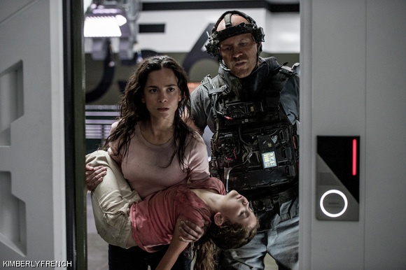 Crowe (Josh Blacker) throws Frey (Alice Braga) and her daughter (Emma Tremblay) into a supply room in Elysium.