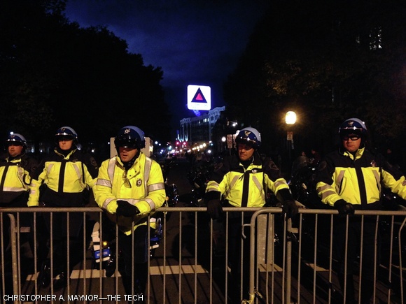 Police officers guarding an entrance into Kenmore Square on Commonwealth Avenue look on as swarms of fans depart the game.